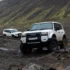 Weisser Toyota Land Cruiser mit 35-Zoll-Bereifung erklimmt eine felsige Geröllpiste im isländischen Hochland