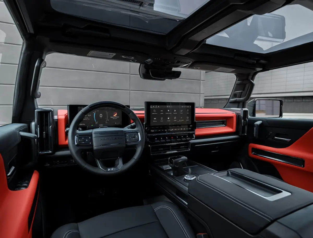 Blick in den Innenraum des Hummer EV mit sportlichen roten Akzenten, grossem Display und transparenten herausnehmbaren Dachteilen