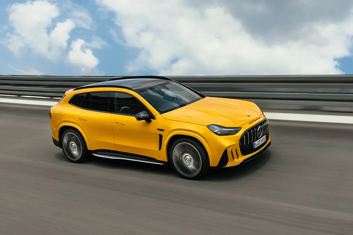 Flache Seitenansicht des rund fünf Meter langen Mercedes-AMG GT SUV in dynamischer Fahrt an einer Leitplanke